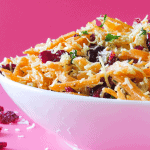 Coconut Carrot Salad in white bowl against pink background