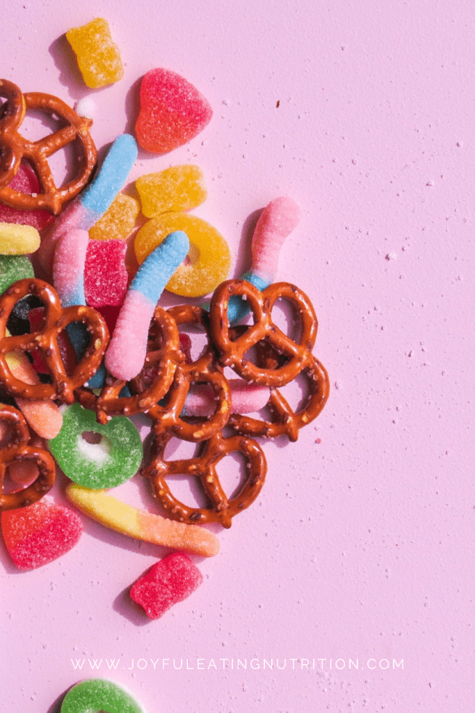 mini pretzels and lollies on pink background