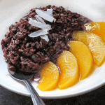 Black Rice Pudding with Coconut Milk and Sliced Peaches in White Bowl