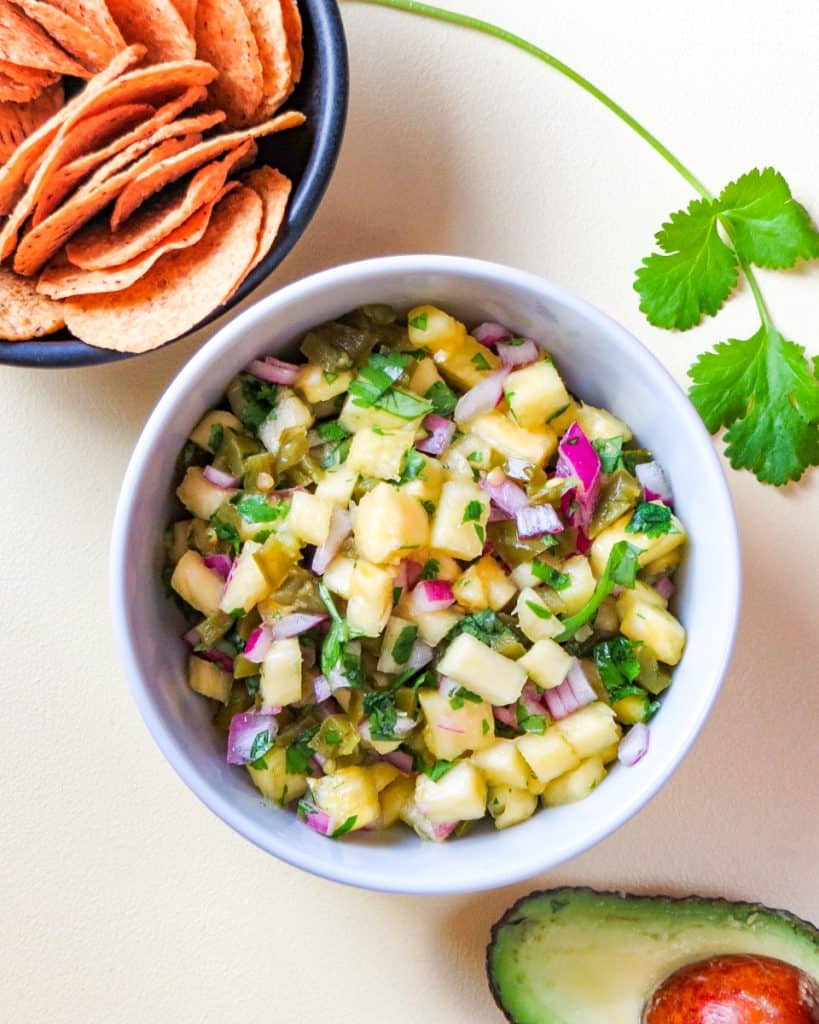 bowl pineapple salsa with corn chips and avocado