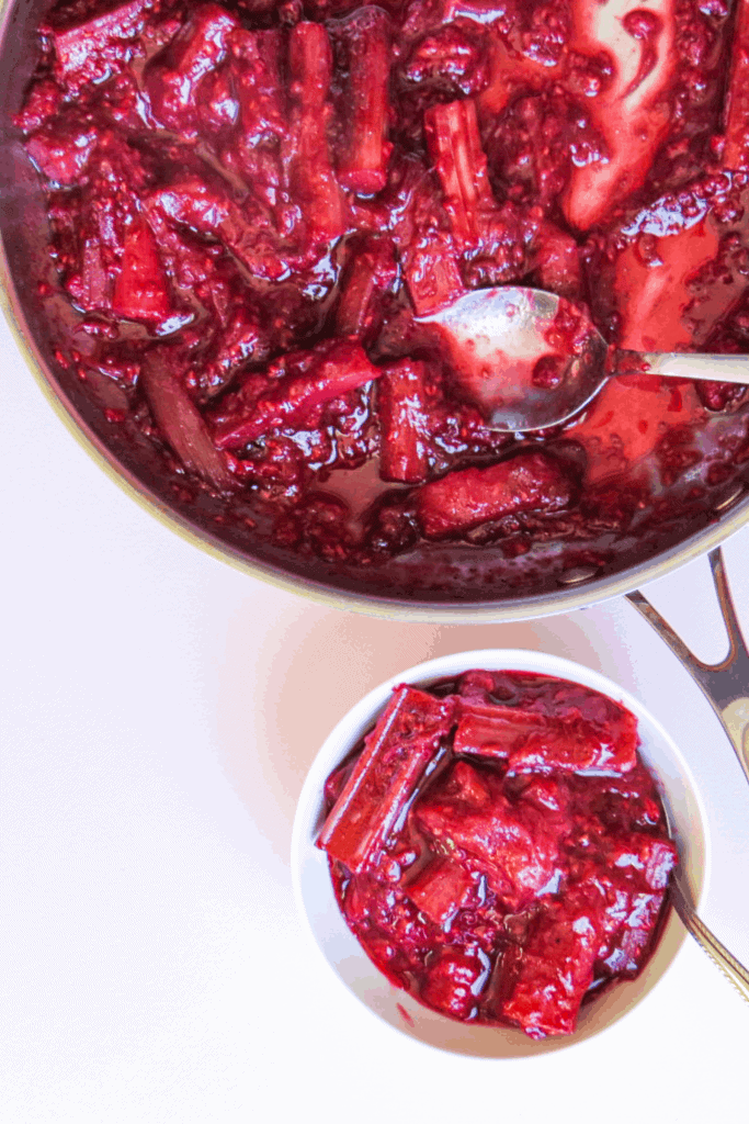 bowl beside a pan of stewed rhubarb and raspberries
