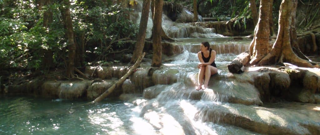 Tansy sitting at Erawan Waterfalls in Thailand