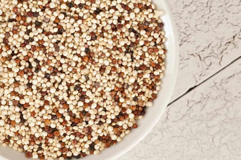tri colour uncooked quinoa in a white bowl