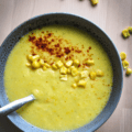 Corn Soup in a blue bowl with a sprinkling of smoked paprika and corn kernels.