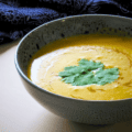Overhead shot of Vegan Pumpkin Soup on light background with blue napkin with Thai pattern.
